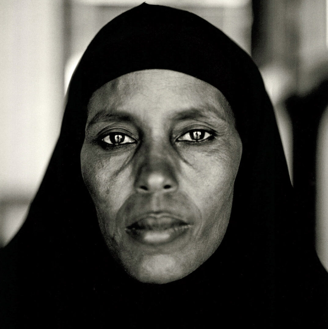 Sepia portrait of a woman in a hijab looking directly into the camera