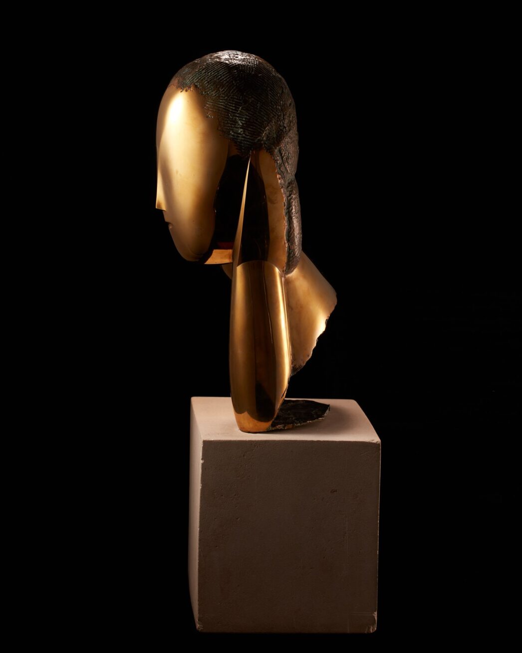 Image description: Muse, Constantin Brancusi, bronze on limestone base, 19 1/2 x 10 x 5 inches. A smooth, bronze, stylized bust of a woman’s head, elongated neck and shoulder. Front view: The woman’s egg-shaped head is smooth except for a raised V shape in the center representing the brow and finishing in a delicate nose. A small mouth is the only other feature on the face. Hair is suggested with rough, textured lines incised into the crown of the head. This texture appears darker than the glossy golden bronze face. A long neck extends from the head at left and is attached to a sloping shoulder. At right, the head seems to rest on a hand and forearm that extends to join the shoulder. The bottom edge of the sculpture has a rough and unfinished appearance. The bust rests on a gray cube of limestone that is juts a bit wider than the sculpture and about half as high. Left profile view: A smooth egg-shaped head smooth except for a small nose at the lower third of the profile. An simple C shaped ear is positioned below the textured hair. A gracefully shaped neck extends forward from a wedge-shaped shoulder. The bronze material folds back on itself, exposing rough edges, to rest on the base. Rear view: The textured hair appears to lengthen past the shoulder area ending in a blunt point. The sculpture’s shoulders fan out into a cone like structure that opens at an angle to expose the unpolished bronze inside. Right profile view: The hand and forearm shapes are visible from this view represented by simple elongated oval shape, a crease at the wrist giving definition to the two parts.
