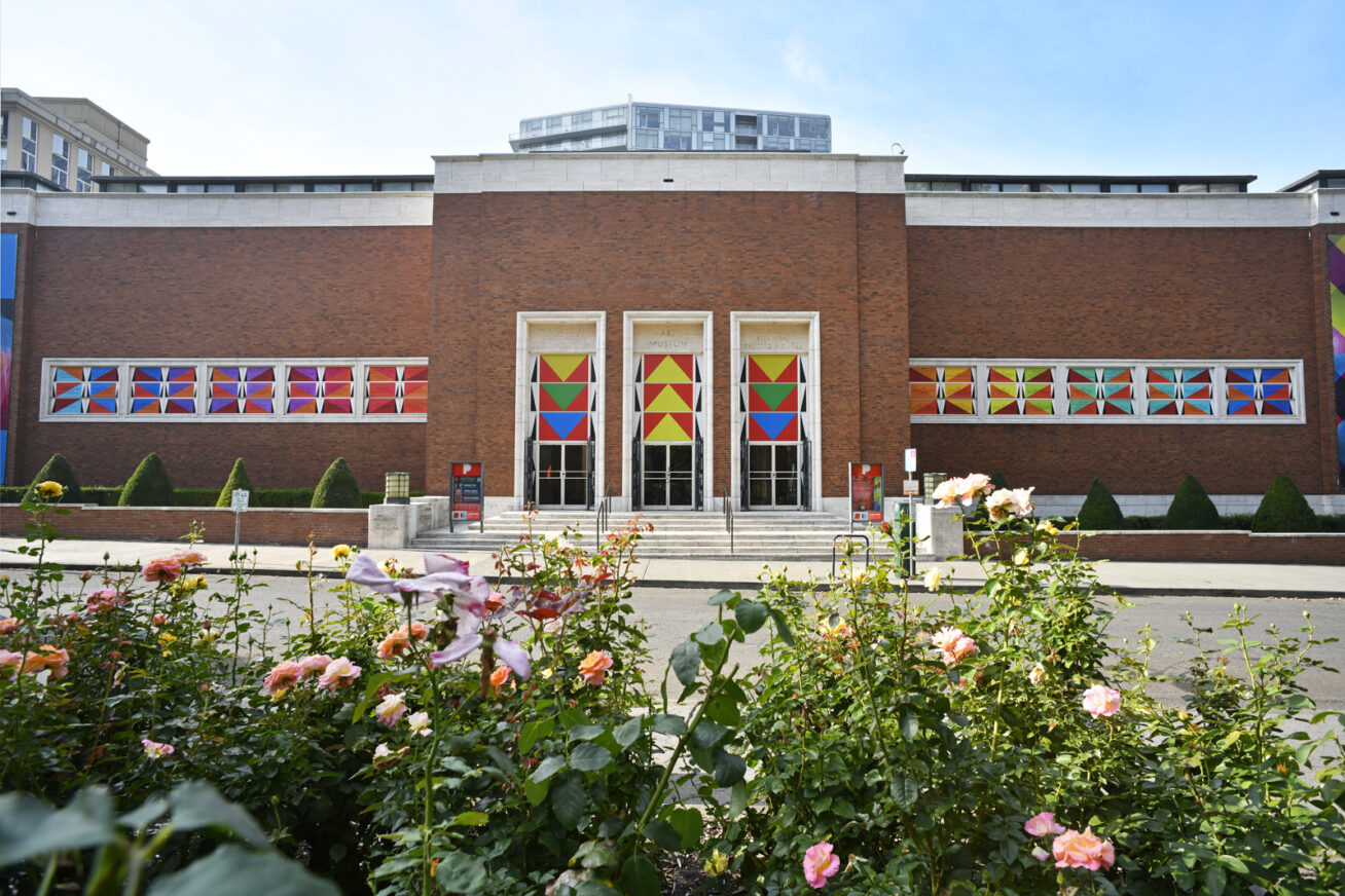 Exterior of Portland Art Museum with Jeffrey Gibson's "TImeline" artwork, consisting of colorful triangular panels of text