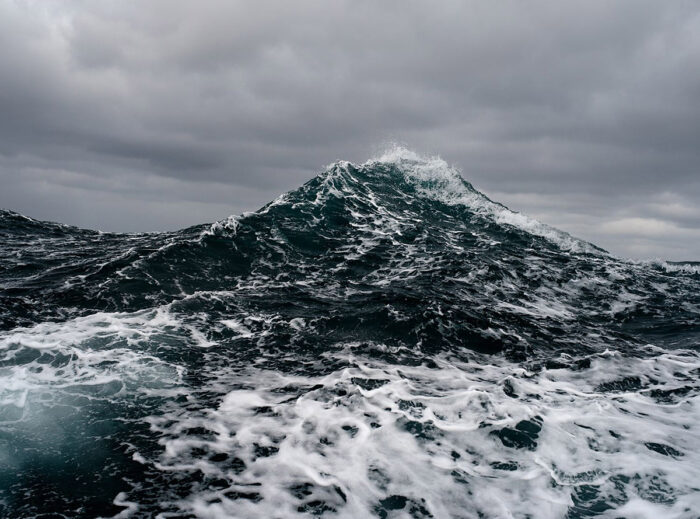 Photograph of a wave under stormy skies