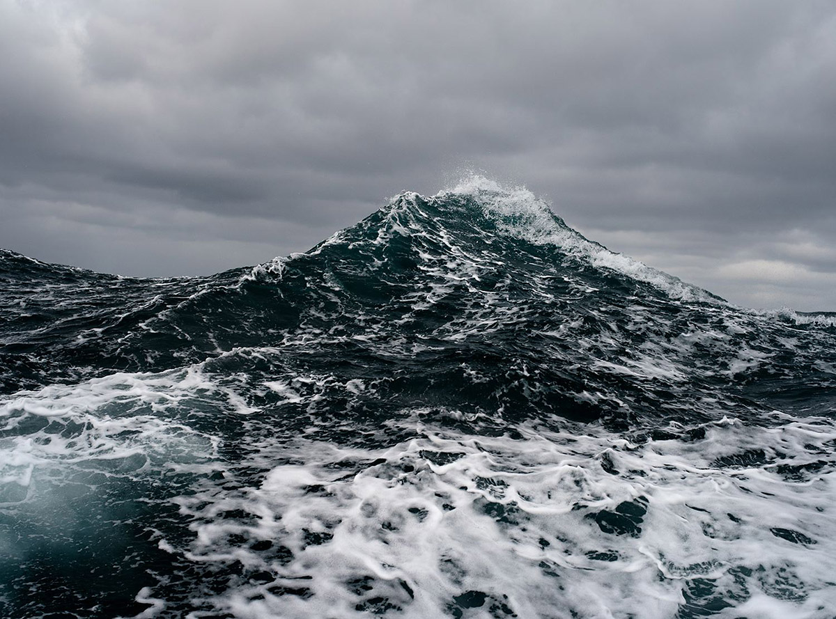 Photograph of a wave under stormy skies