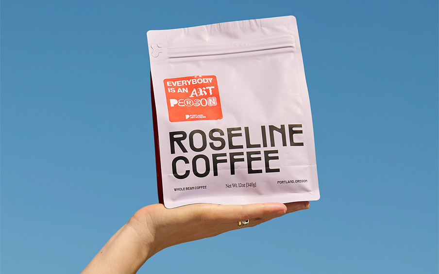 A hand holding up a coffee bag with the text Roseline Coffee.