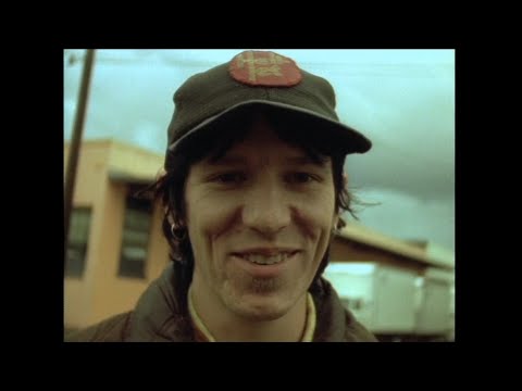 Film still of musician Elliott Smith smiling.