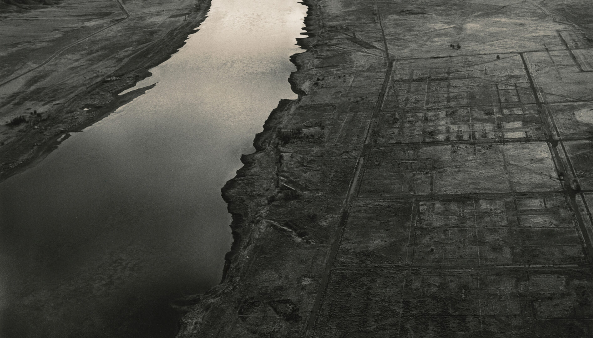 Black and white photo of a river and the surrounding land