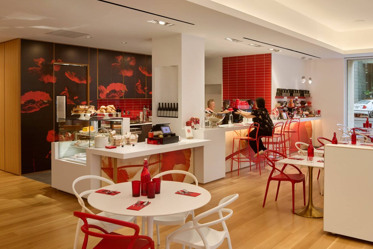 A person seated at a cafe counter being handed a mug.