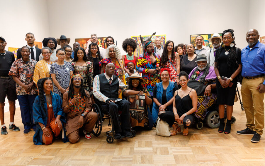 A group of people standing and sitting in a gallery.