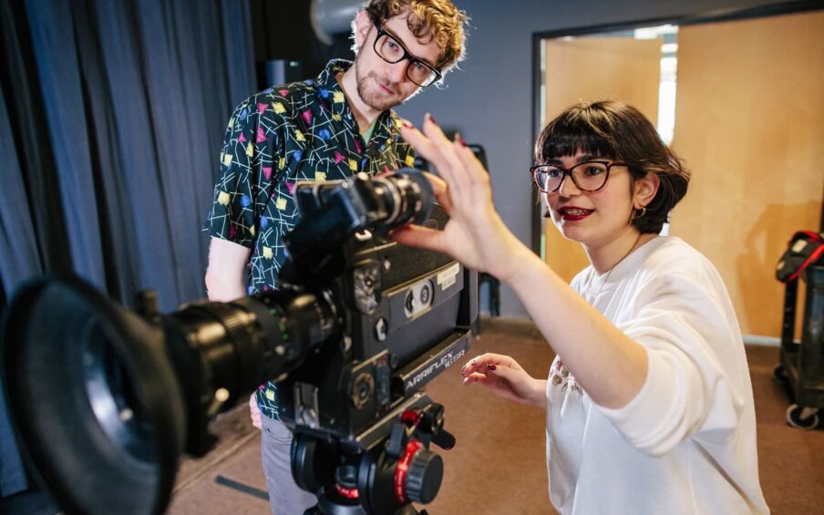 Two people operating a film camera.