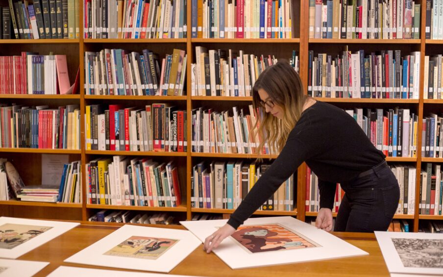 A person examining framed prints.