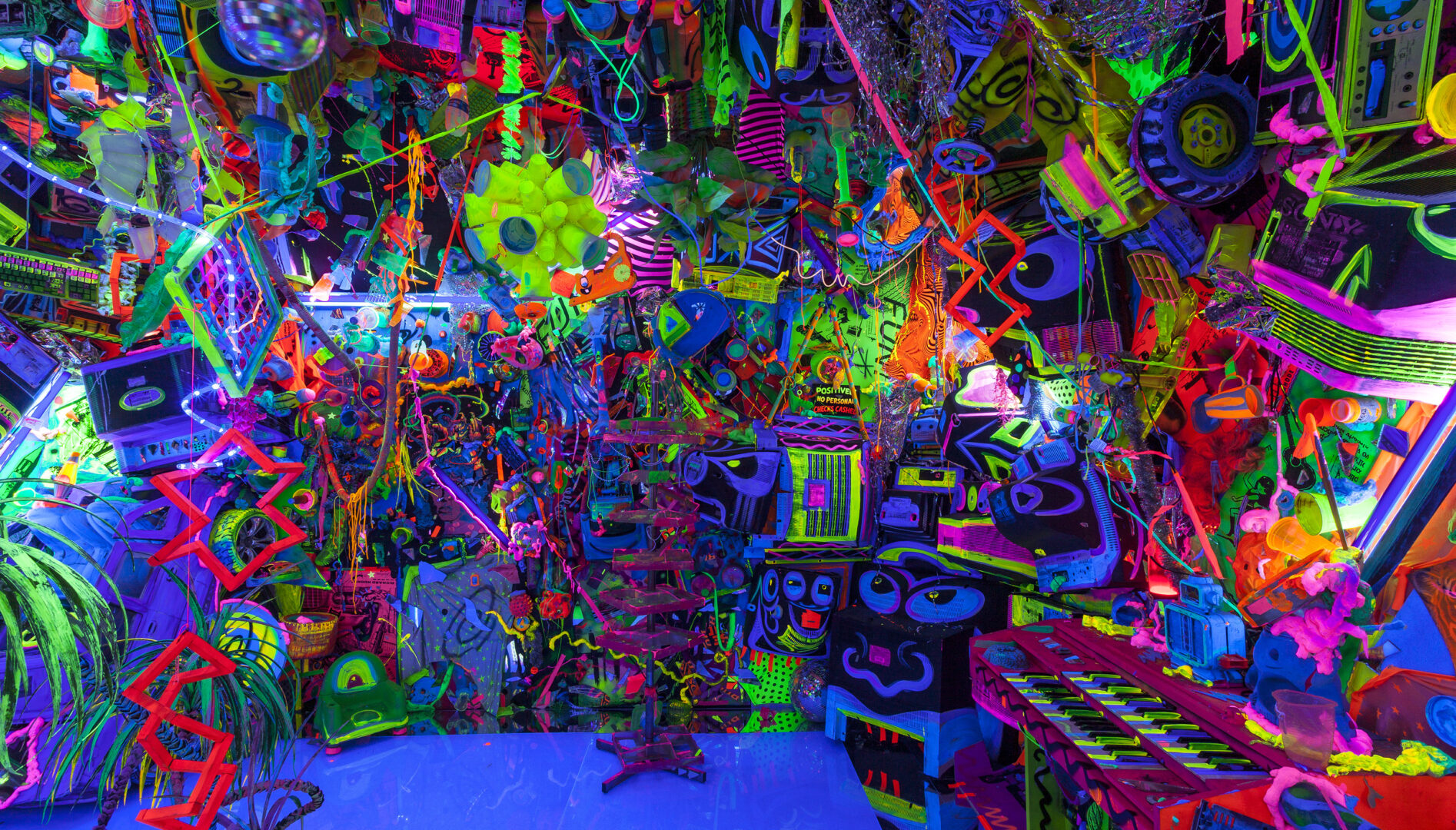 Photo of a dark room filled with day glo objects.