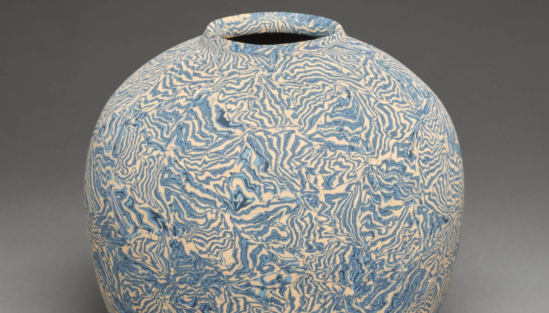 Stoneware jar with blue pattern on white base.