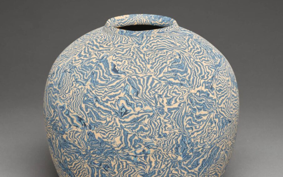 Stoneware jar with blue pattern on white base.