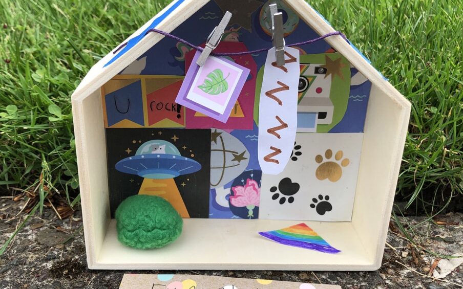 Photo of a diorama-style small wooden house with curated objects in it.