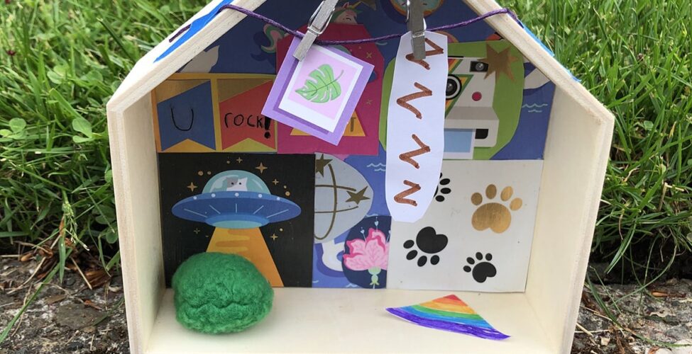 Photo of a diorama-style small wooden house with curated objects in it.