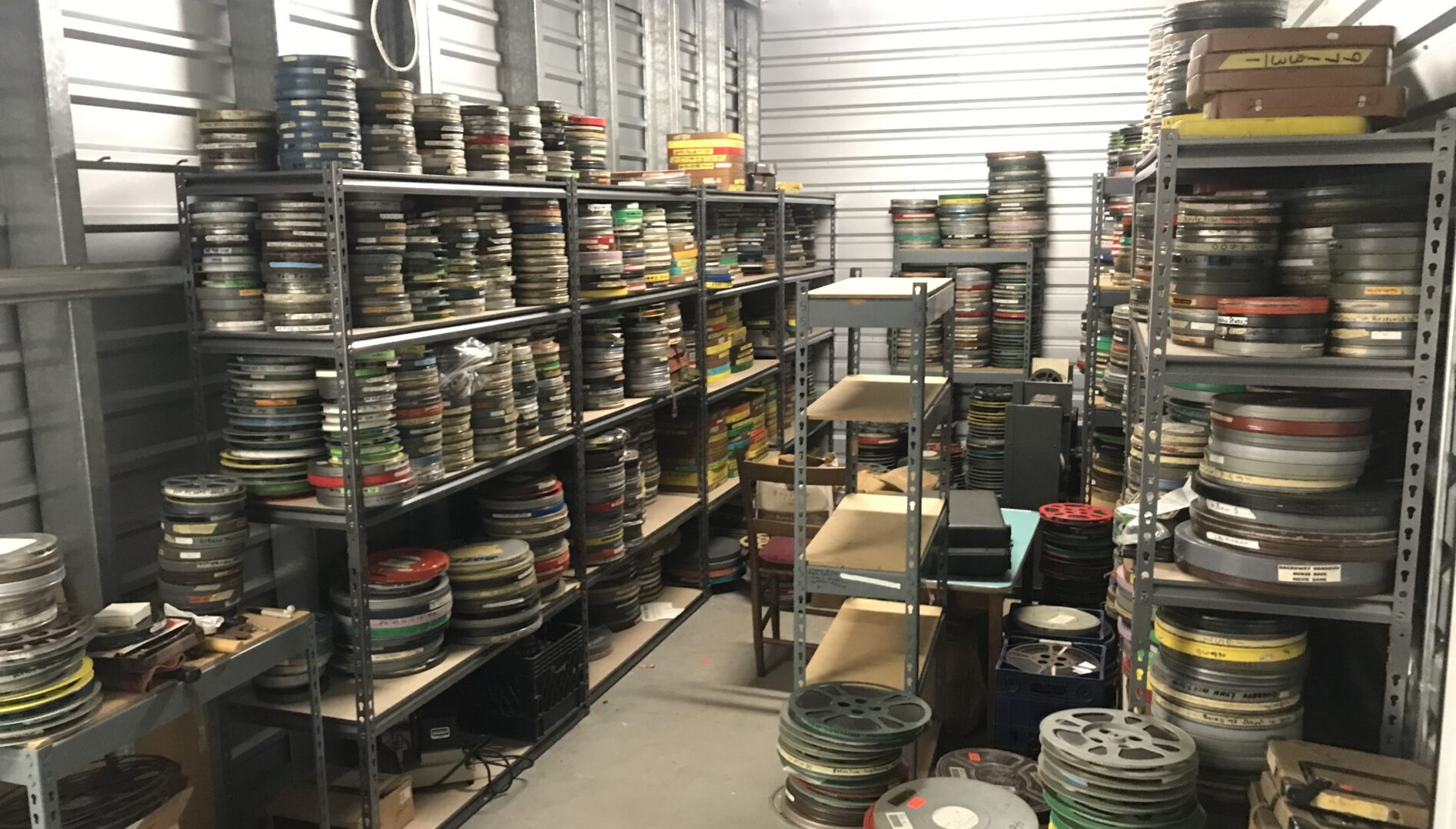 A storage space filled with film reels in canisters.