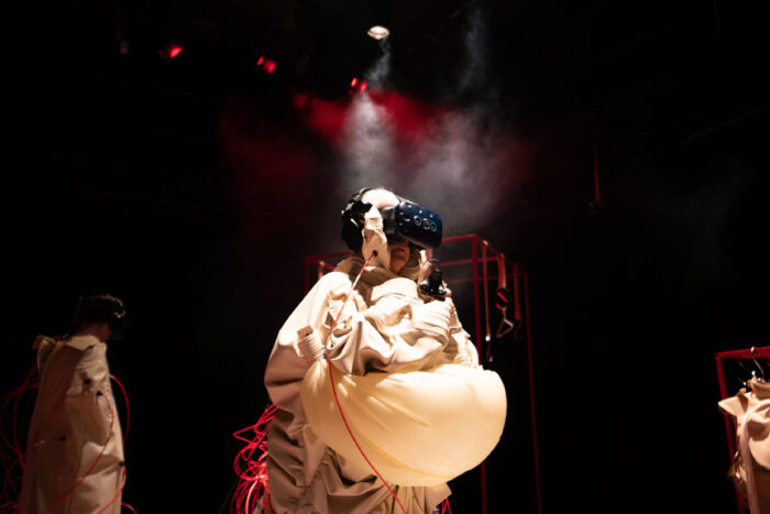 Image of a spotlit person in a haptic suite with a virtual reality headset on