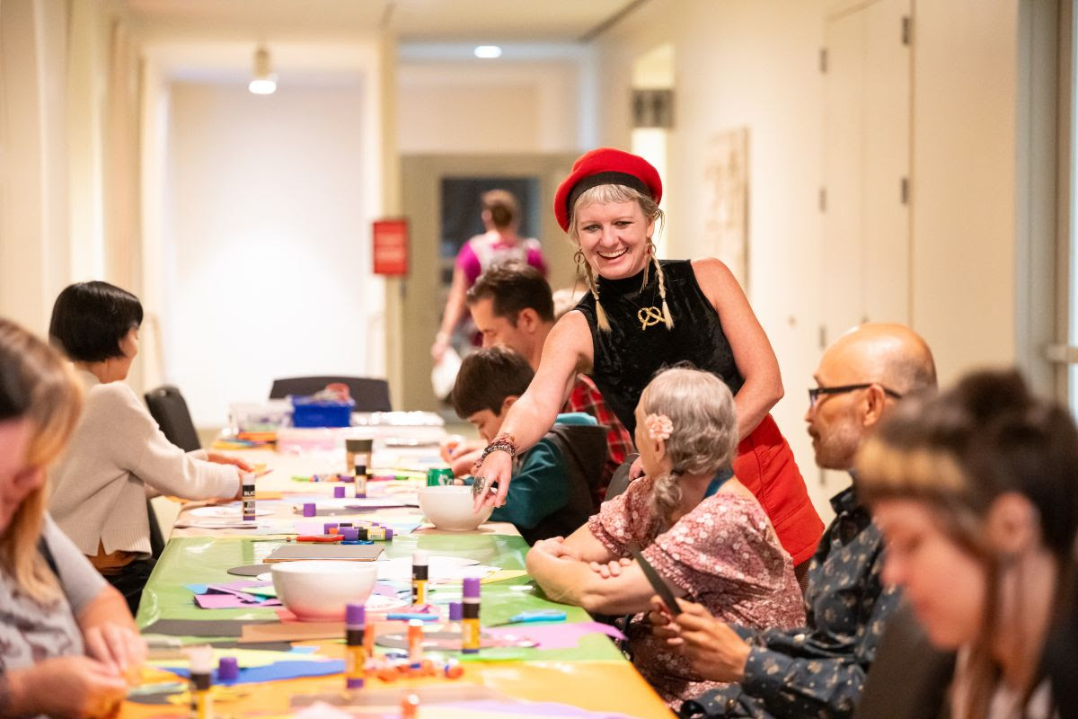 Photo of a woman showing people how to make an art project