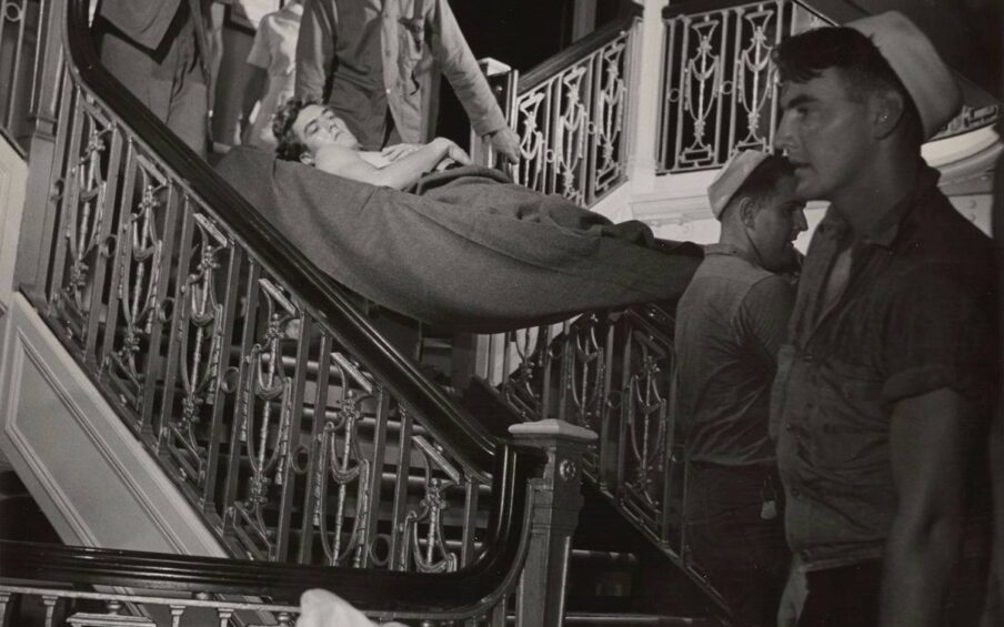 Black-and-white photos depicting quiet scenes of daily life on a hospital ship with sailors cared for by doctors, nurses, and corpsmen.